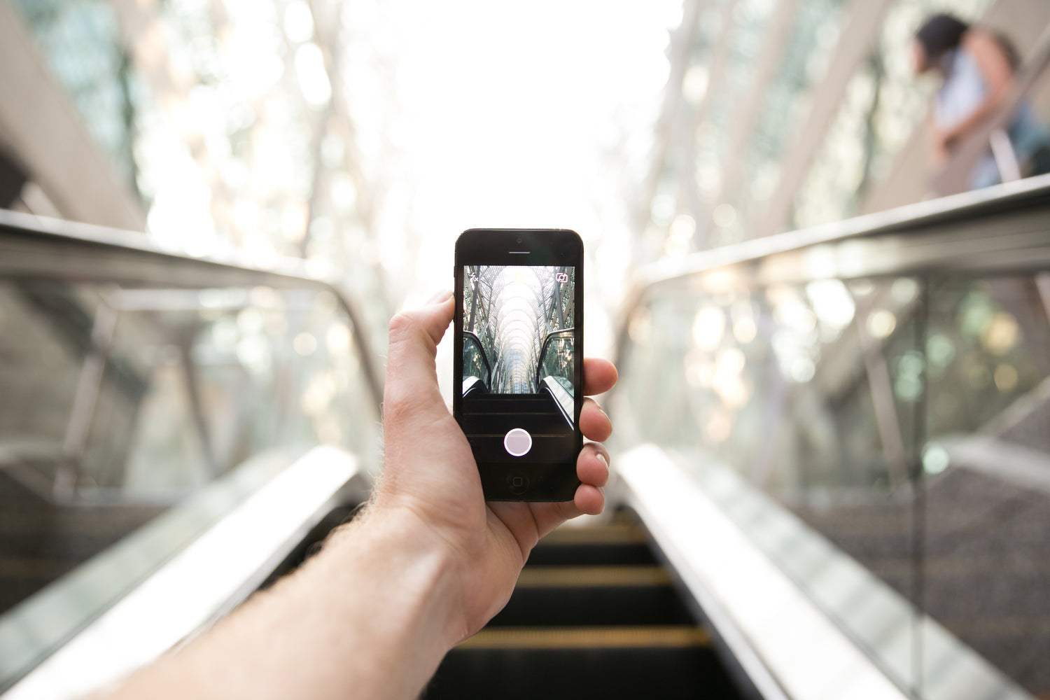 POV photo of man holding his phone as we look through the camera.