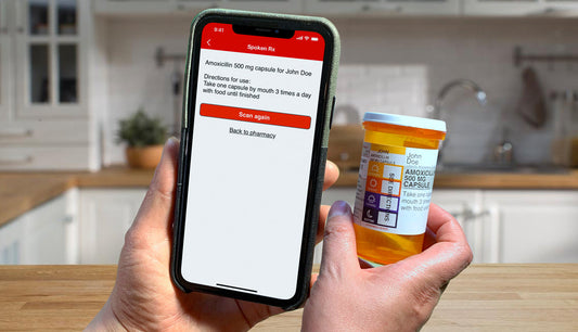 A phone being held up facing a pill bottle with the bottle's information on the phone's screen.