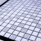 Close up image of the Deluxe low vision scrabble board. The board is black and white and states double, triple letter and word tiles in black