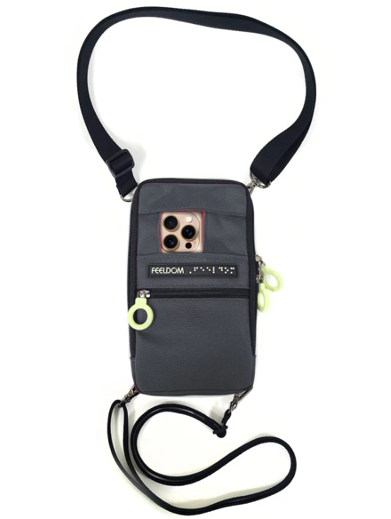 A phone holding pouch with a neck and waist strap for security. The phone has its camera poking out from a pocket in the pouch.