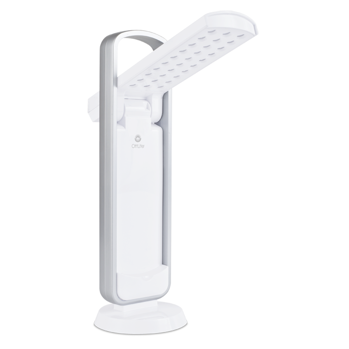 Task lamp in all white with silver handle above. LED lights are visible on the open arm with the Ottlite logo visible. in the center