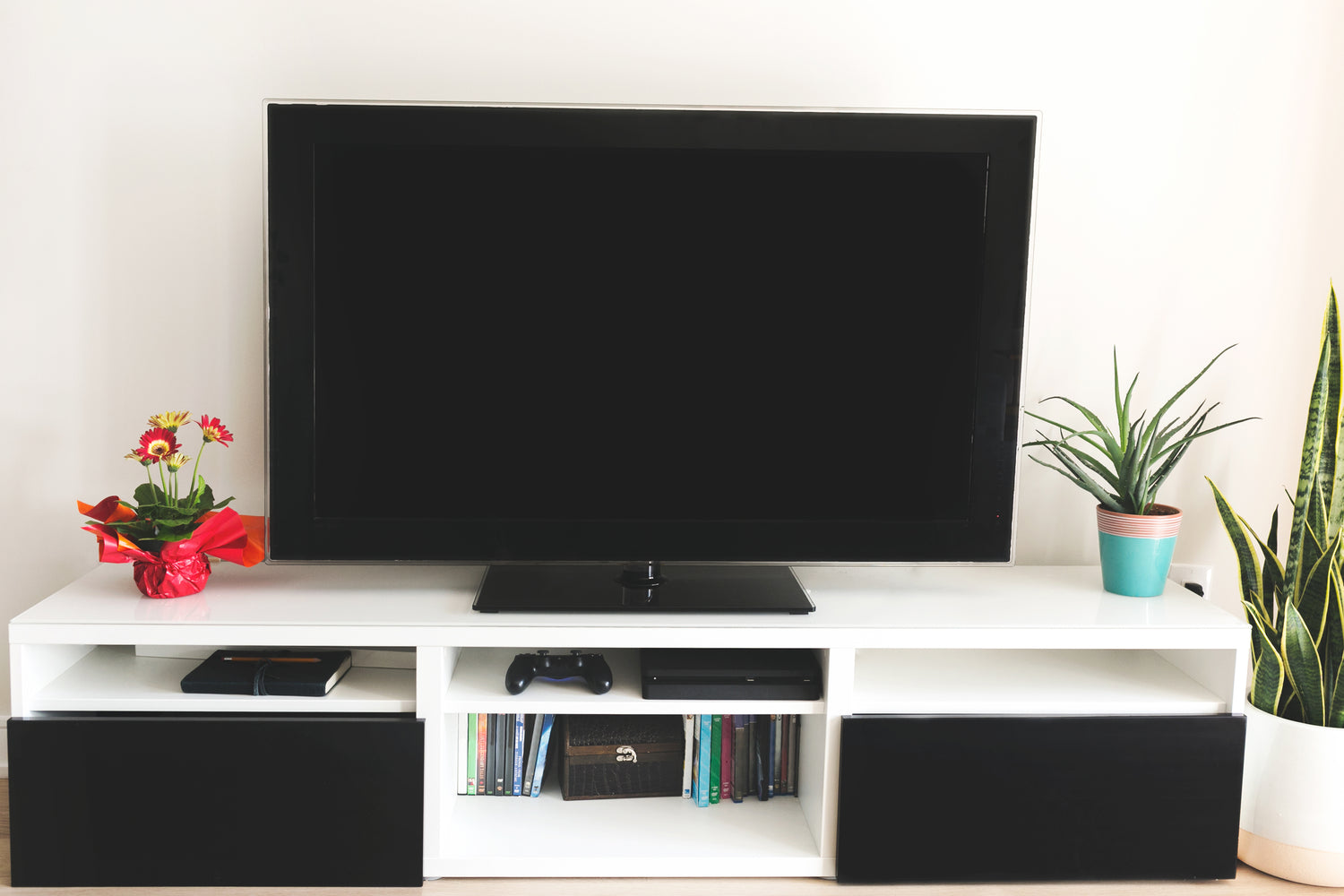 Large flatscreen TV on white TV stand