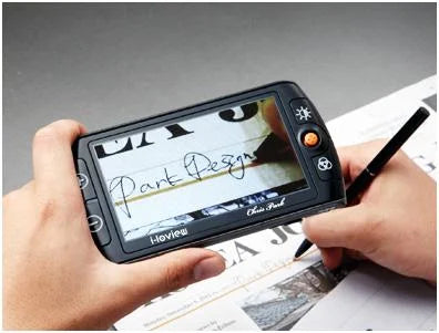 Person holing the i-loview magnifier while signing their name. The screen is magnified to see where they are signing.