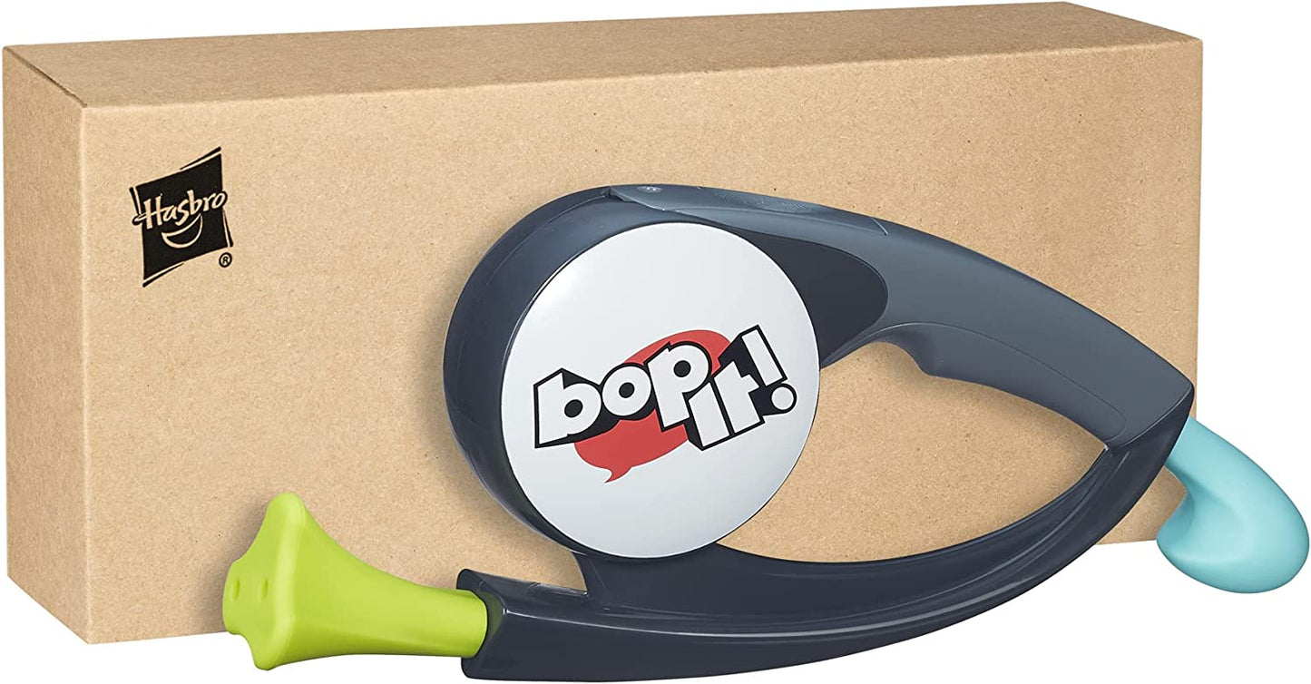 BopIt handheld game in front of brown cardboard box.