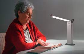 A woman in a red sweater reading a book under the Daylight Twist.