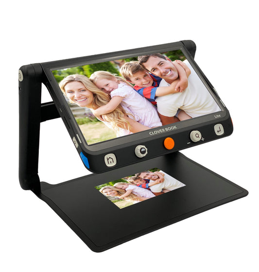 The Irie Cloverbook electronic magnifier in black for independent living. The device has a screen that is magnifying a photograph of a family of 4 underneath it. The screen is on a stable 2 legged, foldable stand and has 5 big buttons at the bottom of the device with an orange one in the middle.