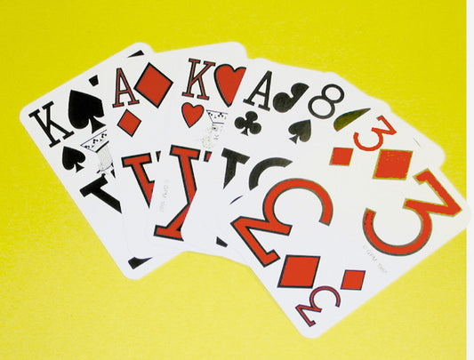 Low Vision Playing Cards By Marinoff are Designed by the ophthalmologist Dr. Gerald Marinoff to enable individuals with a vision to more easily see the numbers on these playing cards. Feature shows cards fand out in an arch revealing it's bold black and red numbers and symbols.